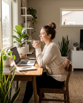 Woman wearing the cordless heated cramp relief belt while working at a desk