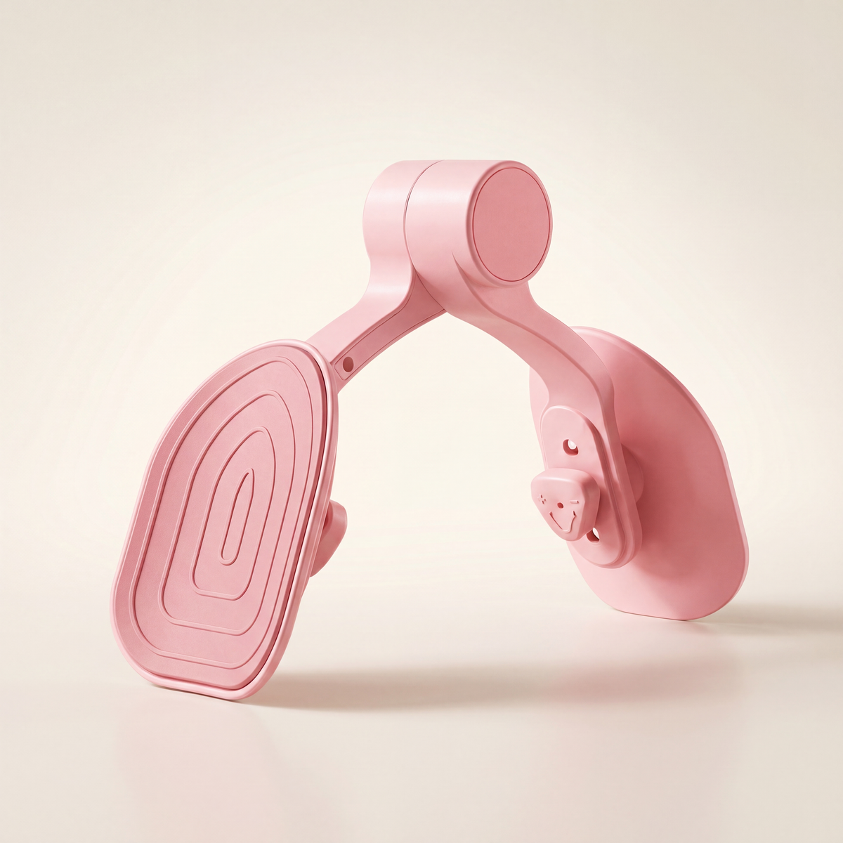 Pink inner thigh toner and leg exerciser on a clean warm off-white studio background